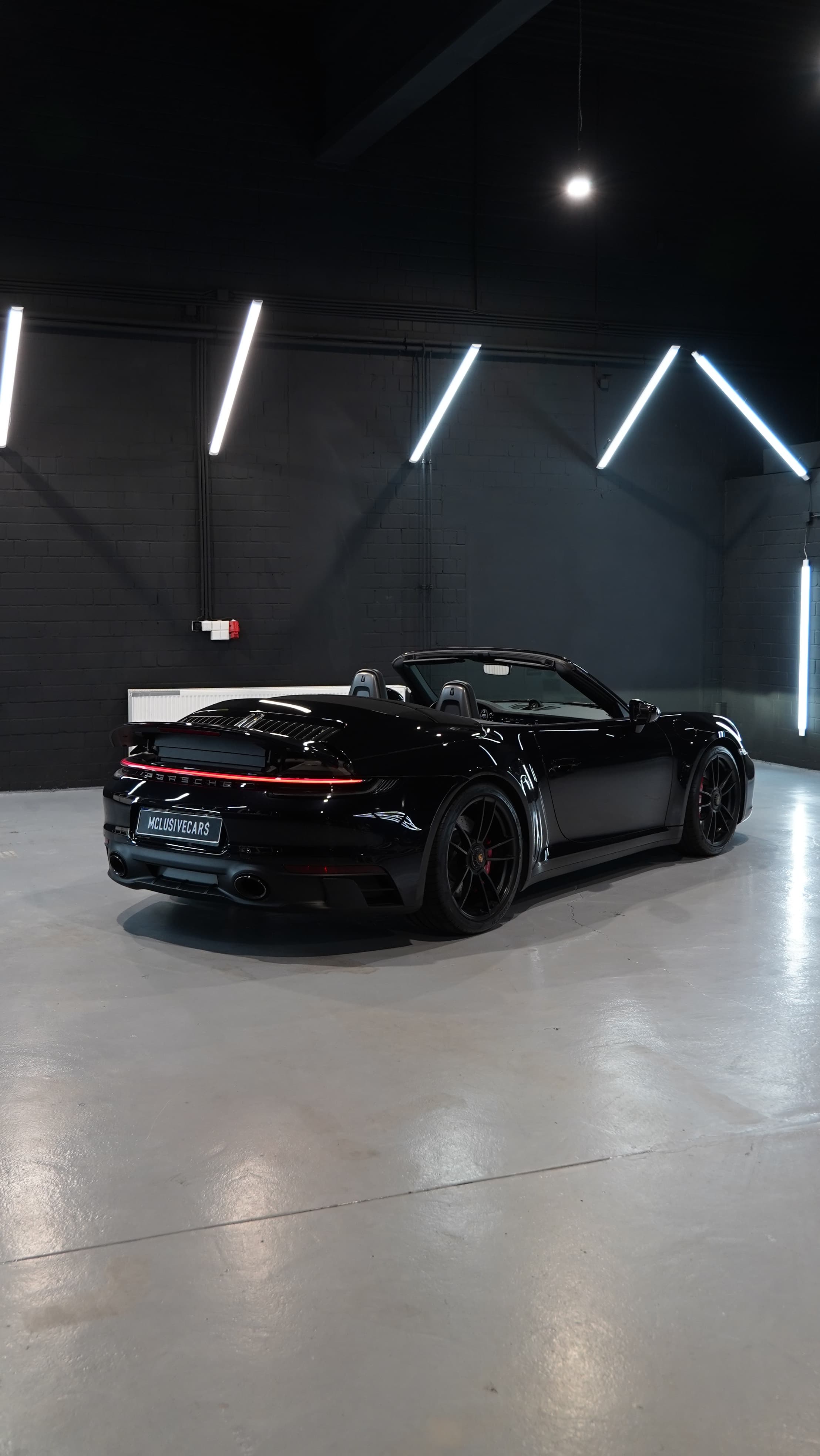 Porsche 911 Carrera 4 GTS Cabriolet in Schwarz, Heckansicht schräg von der Seite
