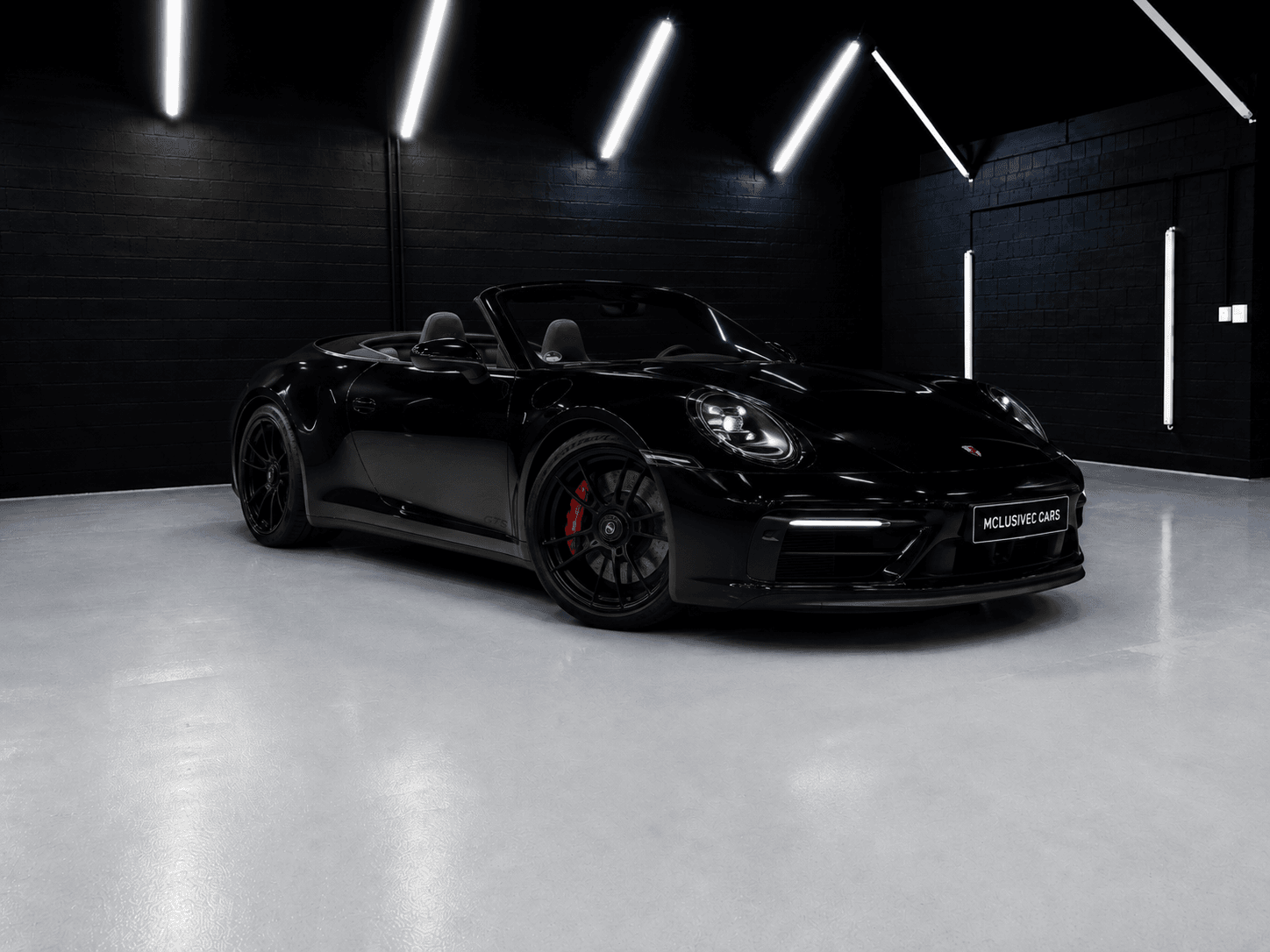 Porsche 911 Carrera 4 GTS Cabriolet in Schwarz – Frontansicht mit offenem Verdeck